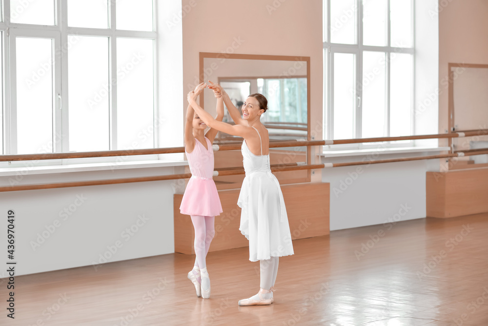 Little ballerina training with coach in dance studio