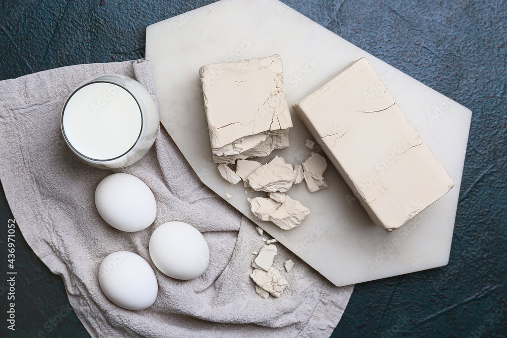 Fresh yeast and eggs on dark background