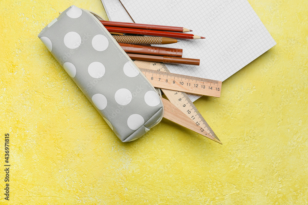 Pencil case and stationery on color background