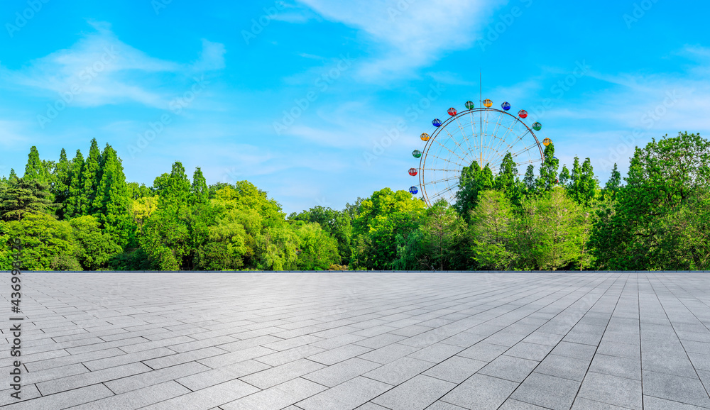 空旷的广场和摩天轮，绿色的森林景观。