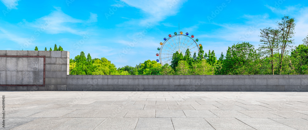 空旷的广场和摩天轮，绿色的森林景观。