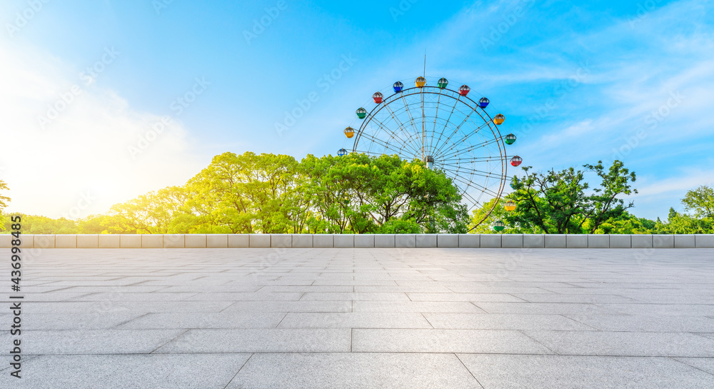 空荡荡的广场地板和摩天轮，绿色的森林景观。