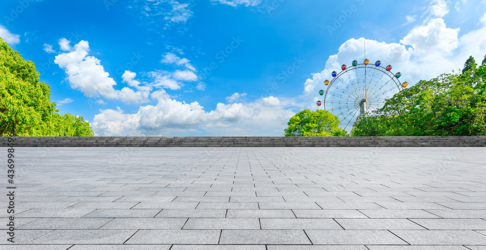 空旷的广场和摩天轮，绿色的森林景观。