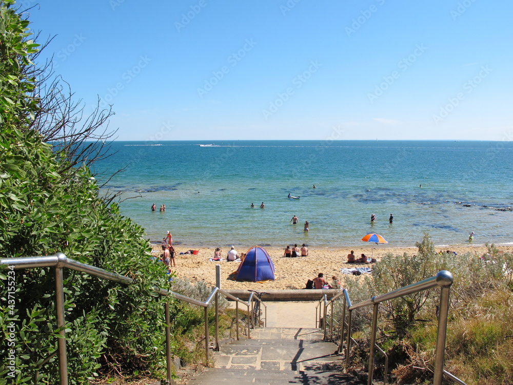 Staircase to  Sandringham beach at Melbourne, Australia. Have people walking, swimming and sunbathin