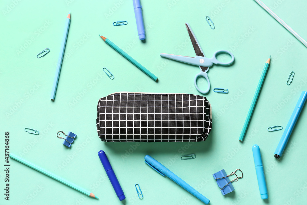 Pencil case with stationery on color background