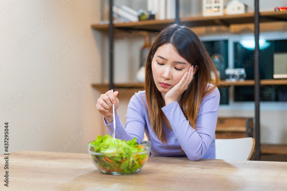 Asian woman bored to eat vegetable salad want to quit vegetarian