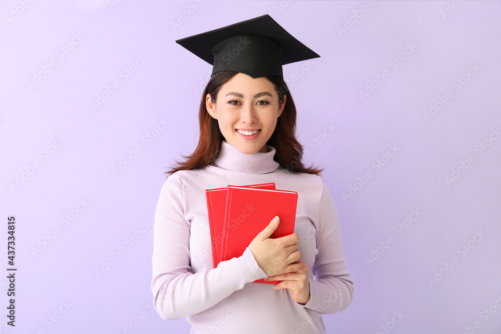 Female graduating student with books on color background