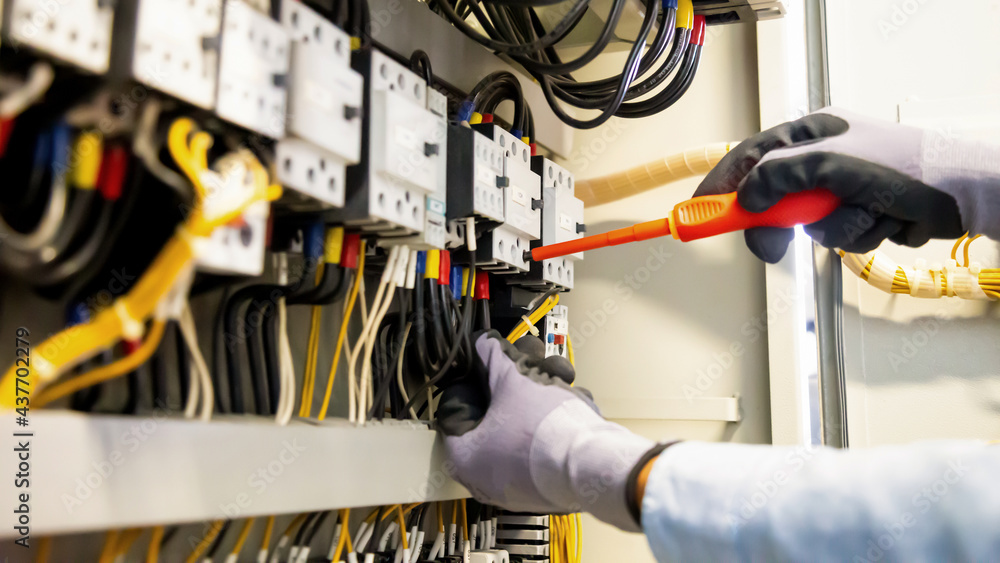 Electricians work to connect electric wires in the system, switchboard, electrical system in Control