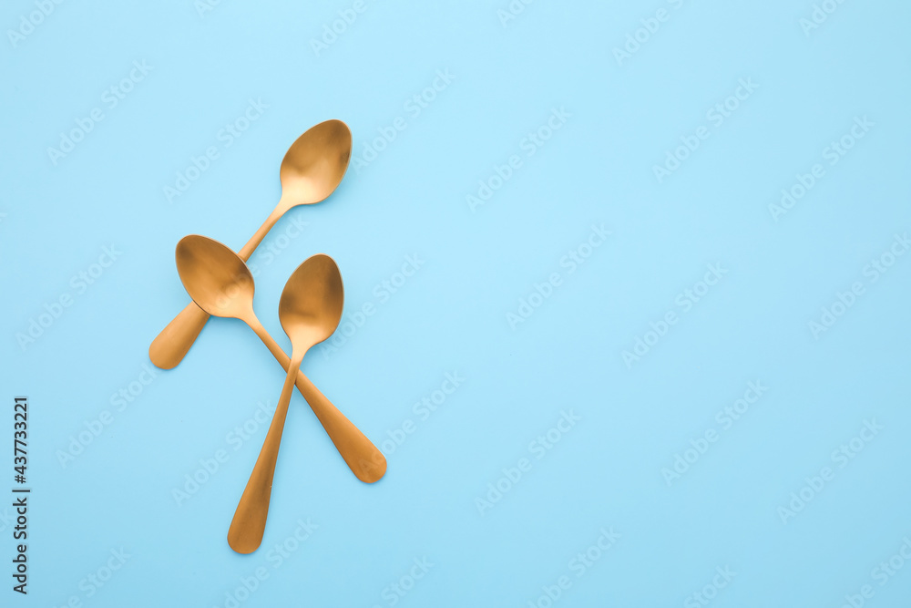 Clean spoons on color background