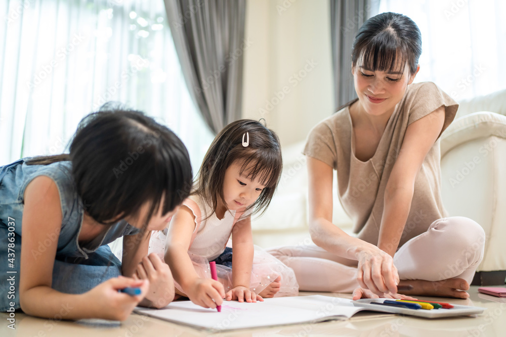 父母妈妈和兄弟姐妹女孩在地板上画画和彩绘很有趣