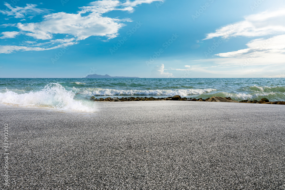 Asphalt road and beautiful seaside scenery under blue sky.