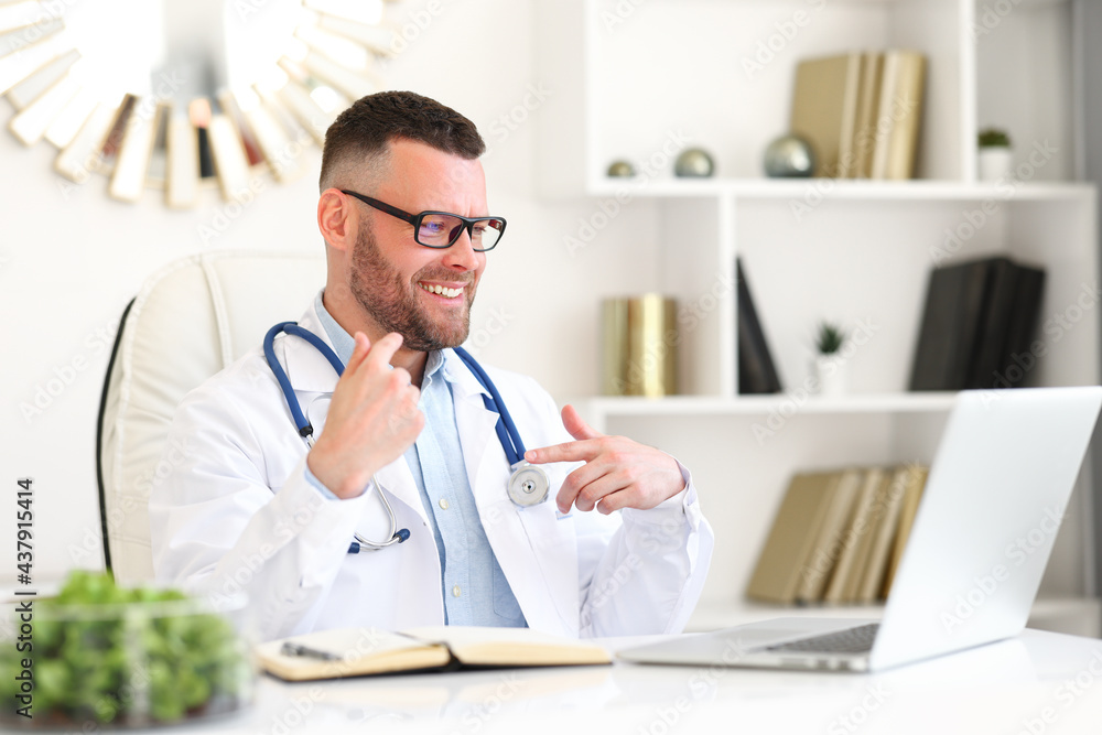 Positive professional male doctor in white coat giving professional medical consultation to patient 