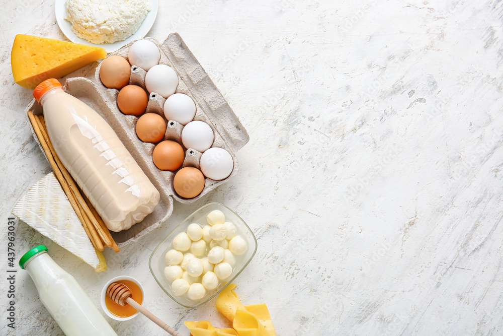 Different dairy products, chicken eggs, honey and grissini on light background