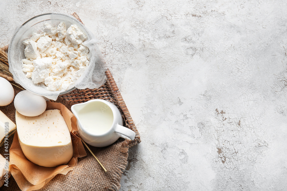 Tray with different dairy products and chicken eggs on light background