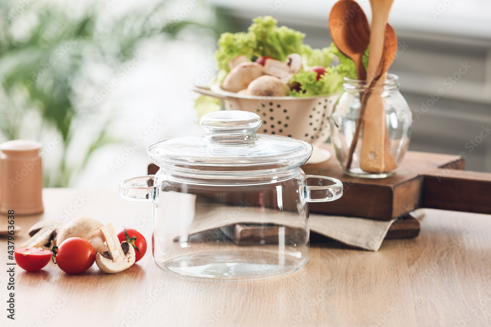 Stylish cooking pot and fresh vegetables on table in kitchen