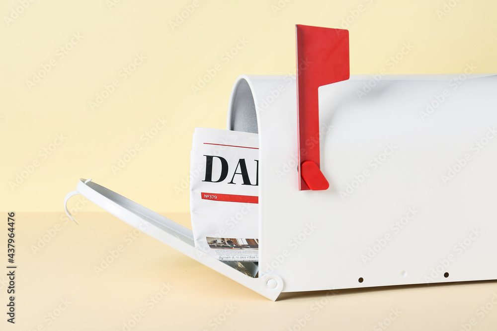 Mail box with newspaper on color background