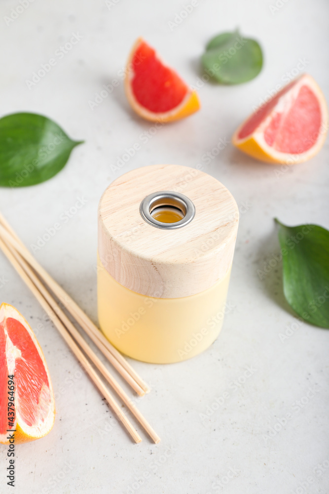 Reed diffuser with grapefruit on light background