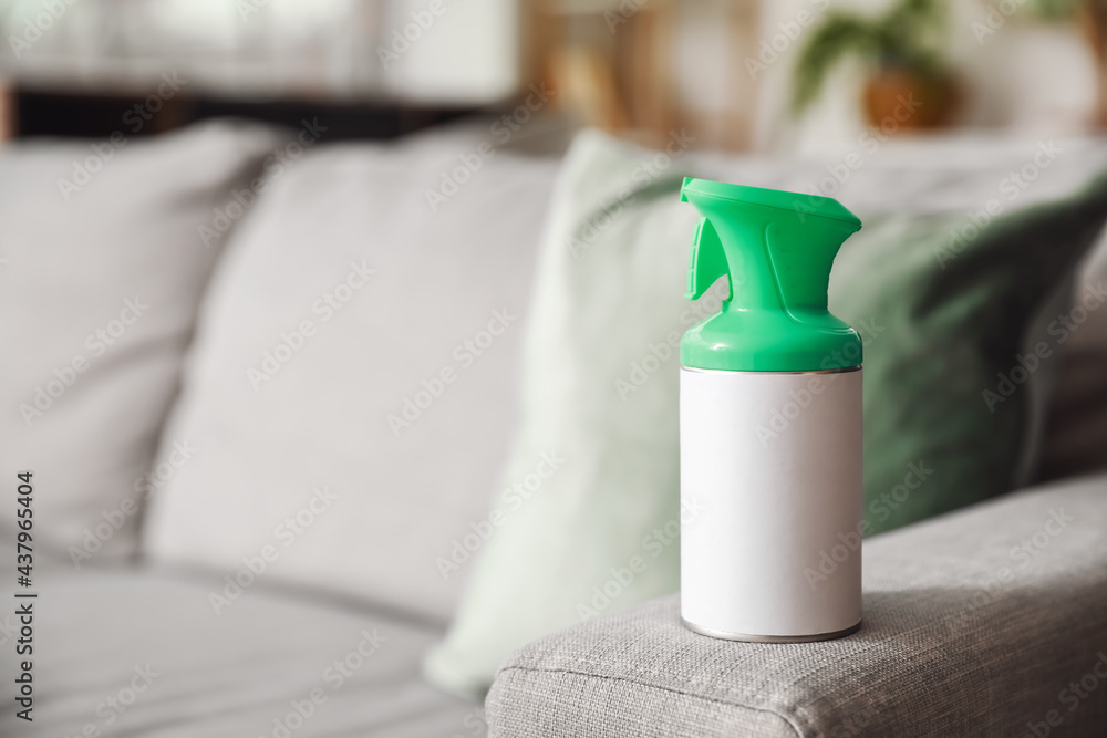 Bottle of air freshener on sofa in room, closeup