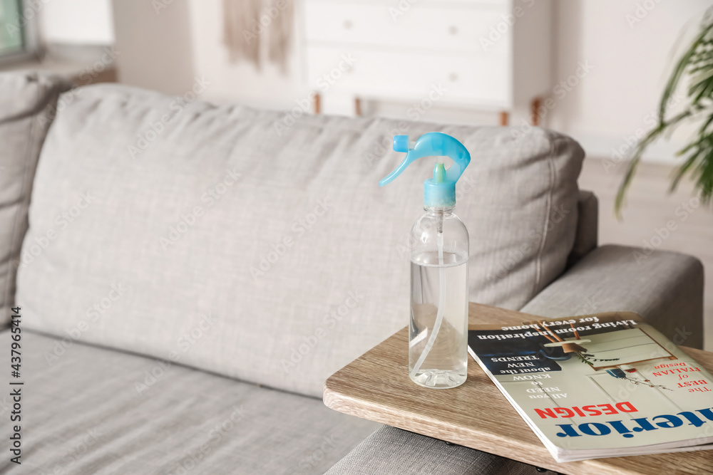 Bottle of air freshener and magazine on table in living room