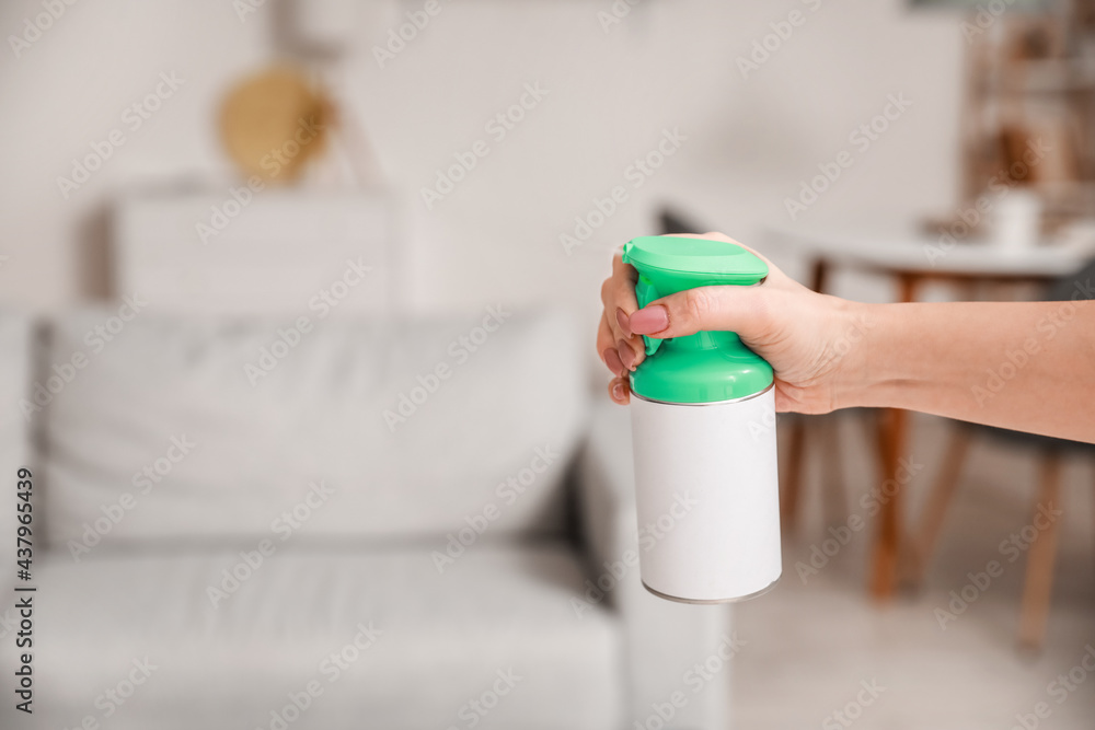 Young woman with air freshener at home, closeup