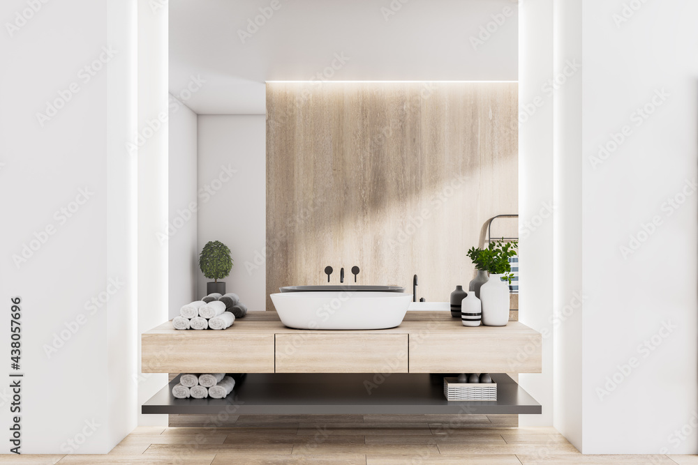 Stylish sunny eco design bathroom with wooden wall and countertop, white washbasin, rolled towels an