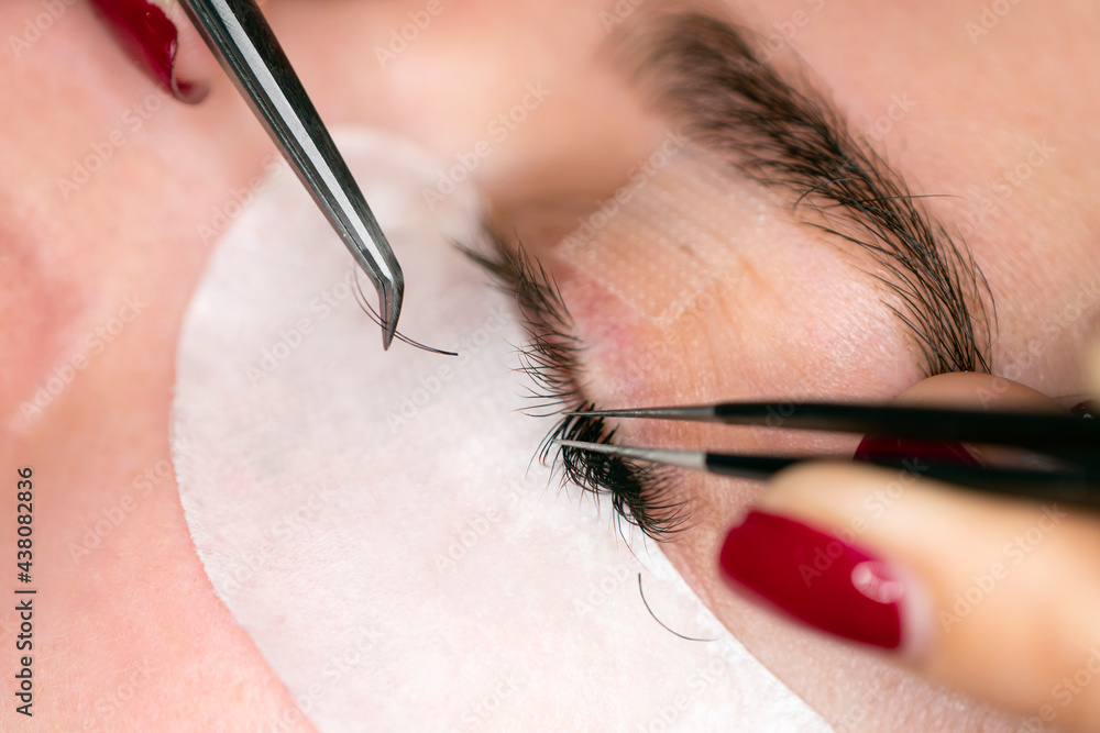 Woman Eye with Long Eyelashes. Eyelash Extension. the process of gluing eyelashes on the eye. Lashes