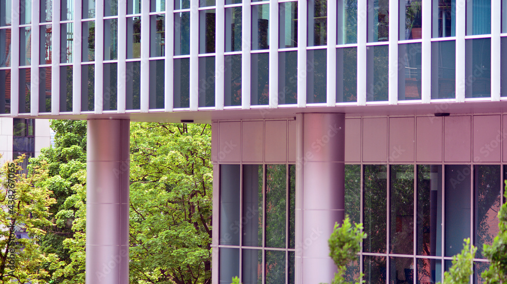 Abstract closeup of the glass-clad facade of a modern building covered in reflective plate glass. Ar