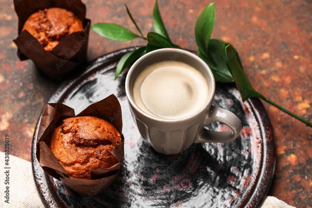 Cup of freshly brewed coffee and muffins on table