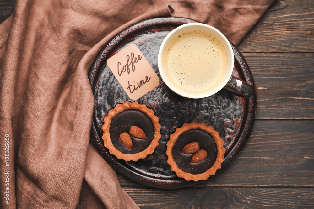 Cup of freshly brewed coffee and cookies on wooden table