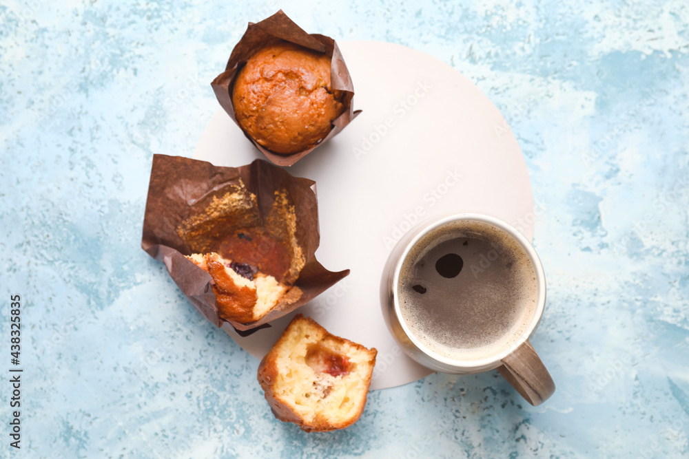 Cup of freshly brewed coffee and muffins on table