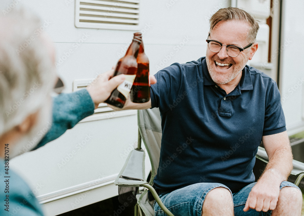 Happy senior men clinking bottle beers