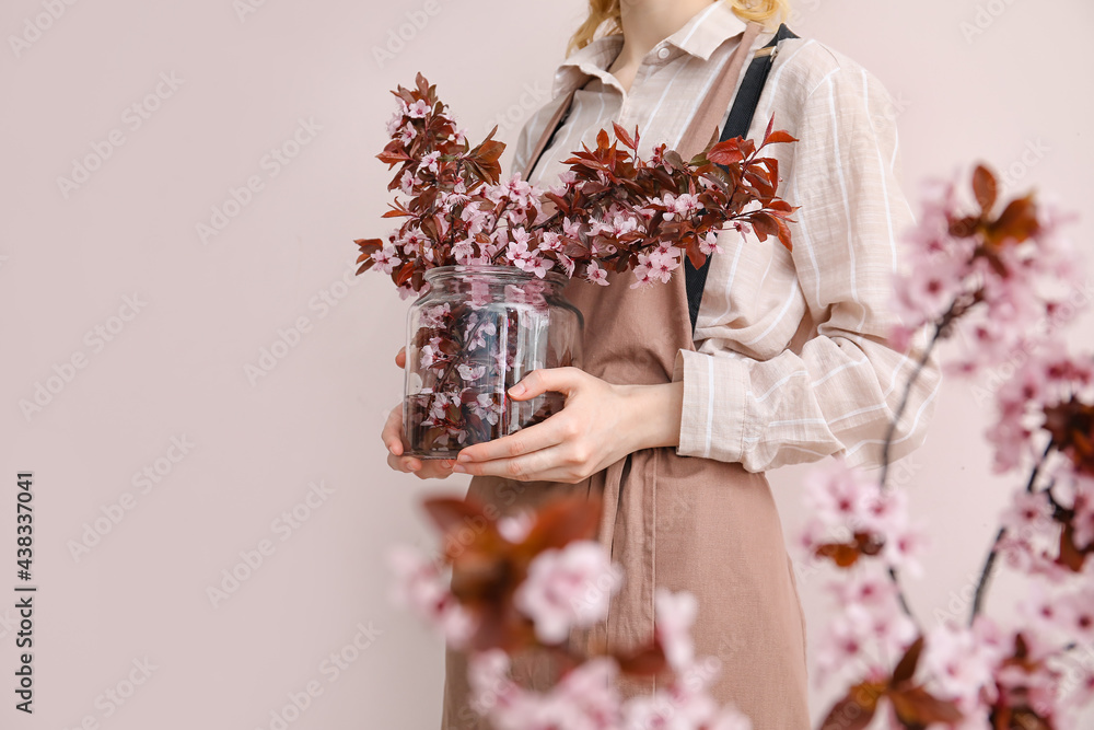 彩色背景上有美丽的开花树枝的女人