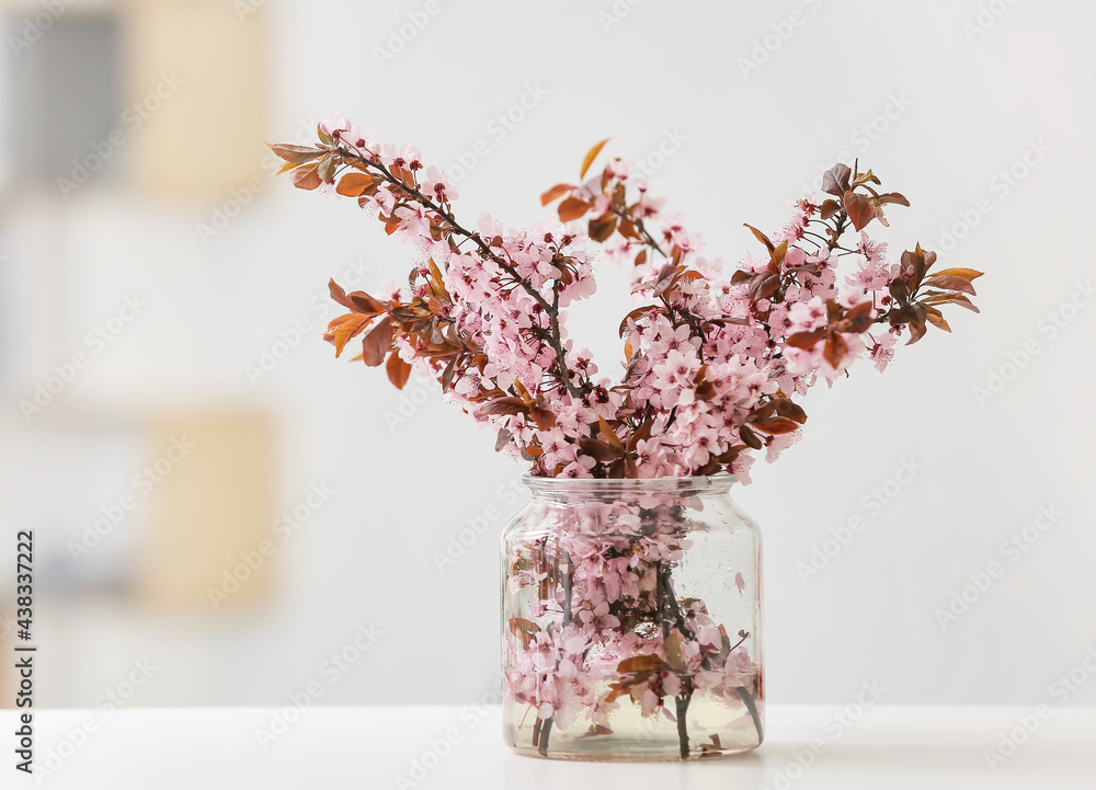 房间桌子上有漂亮的开花树枝的花瓶