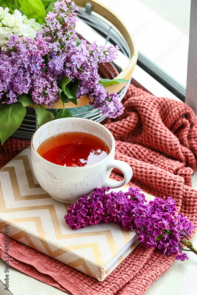 窗台上有一杯茶的丁香花