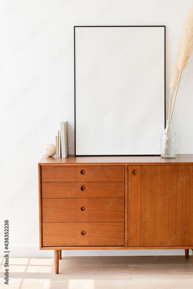 Blank picture frame on a wooden cabinet