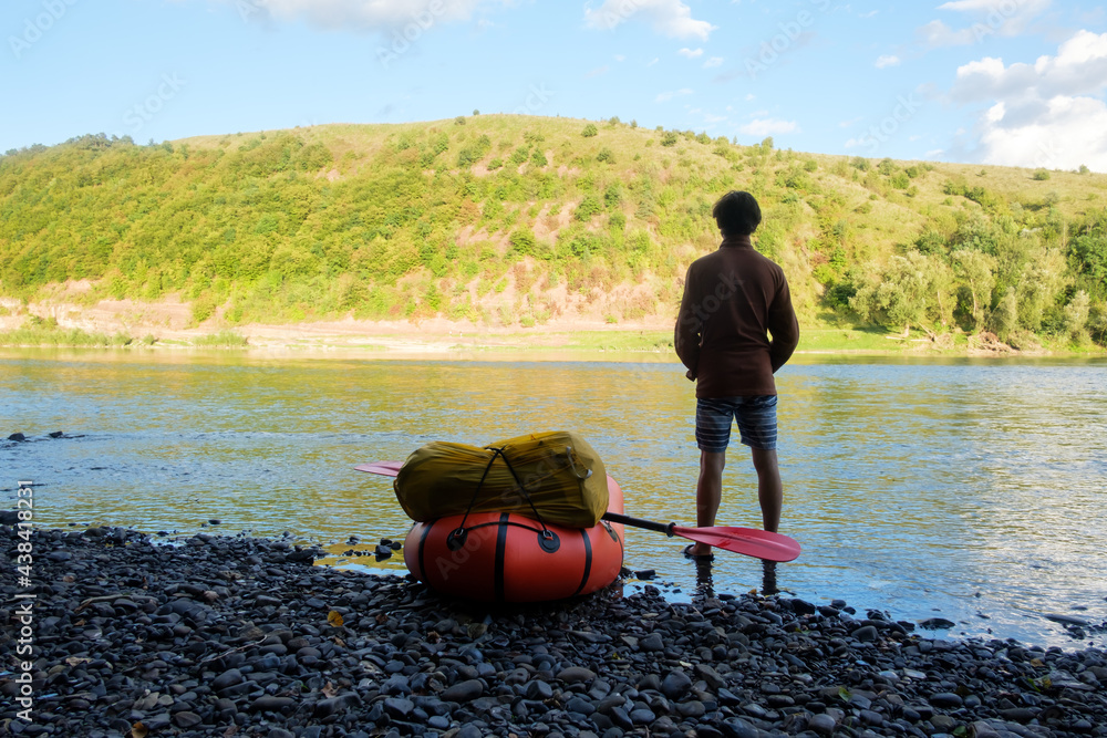 Tourist on yellow packraft rubber boat with red padle