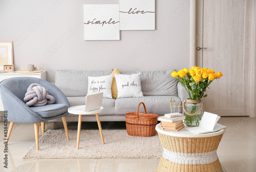 Interior of stylish living room with vase and yellow roses