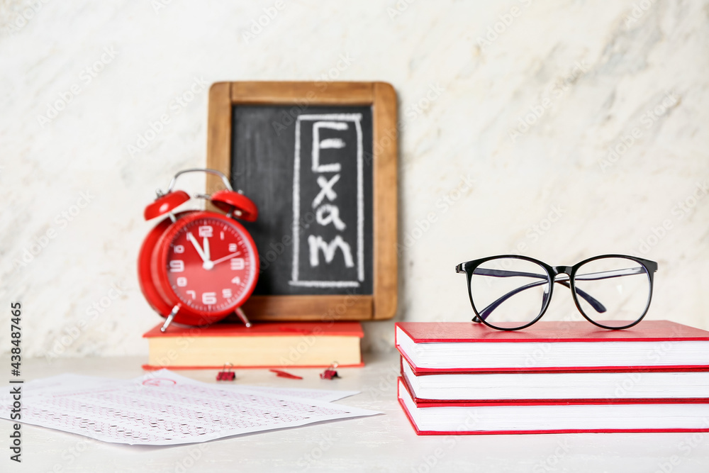 Stack of books and answer sheet forms on white background