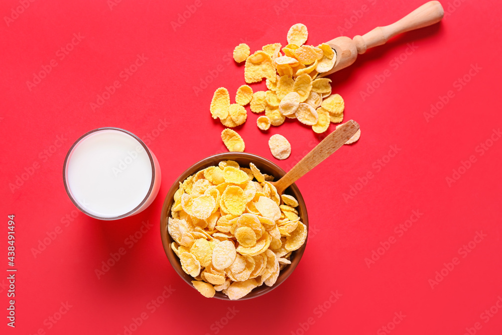 Glass of milk and tasty corn flakes on color background