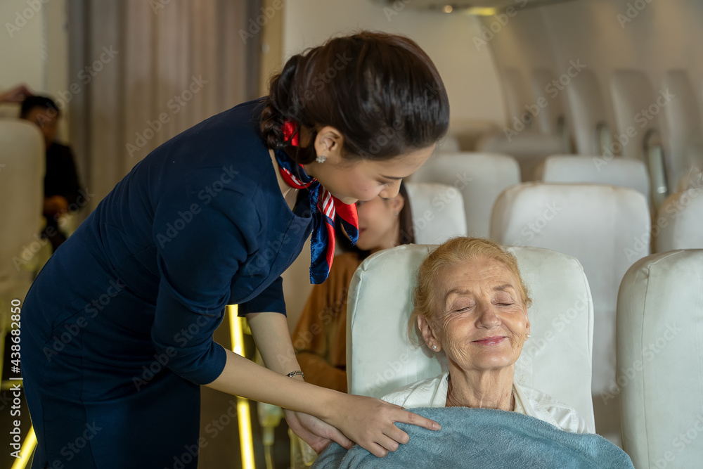 乘务员在飞机上给乘客系毯子，航空运输和旅游概念