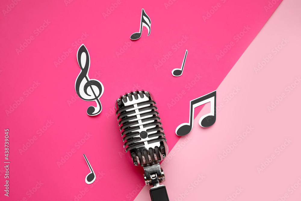 Retro microphone with music notes on color background