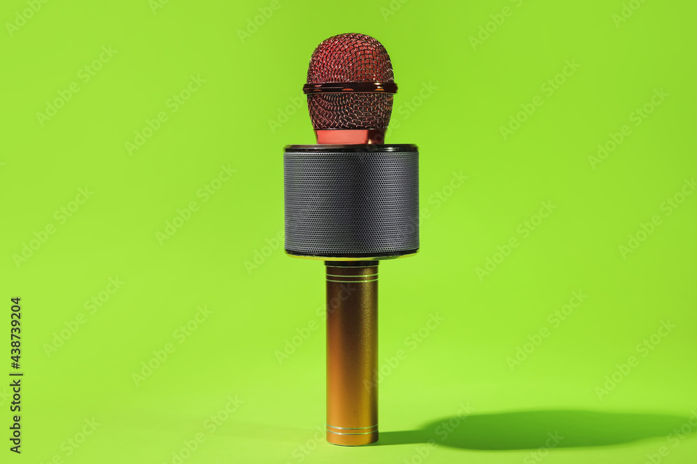 Modern microphone on color background