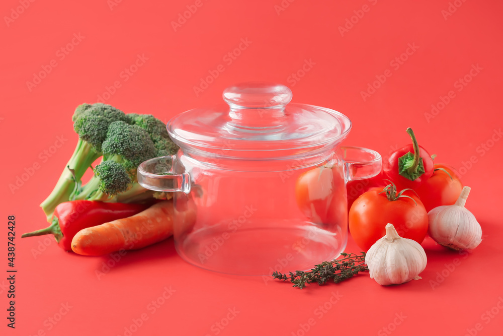 Stylish cooking pot and products on color background