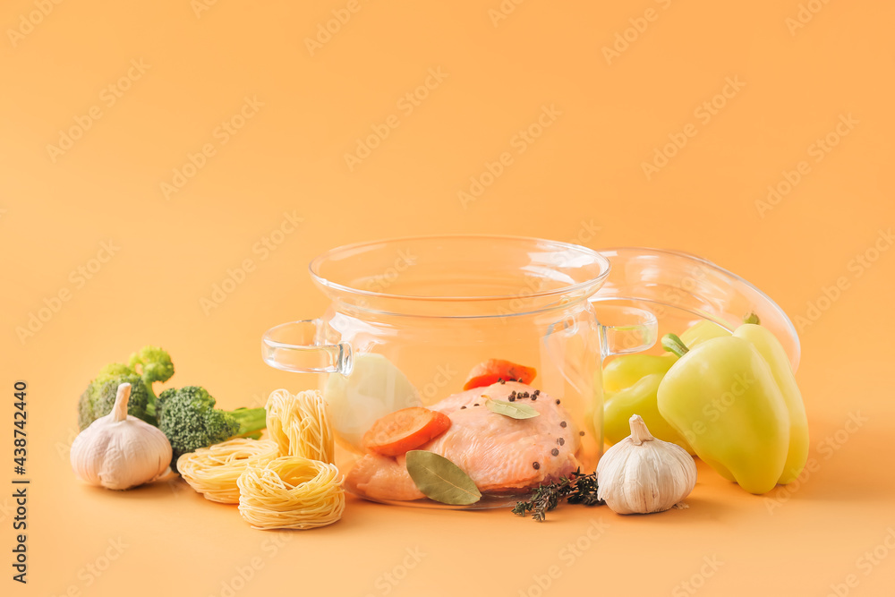 Stylish cooking pot and products on color background