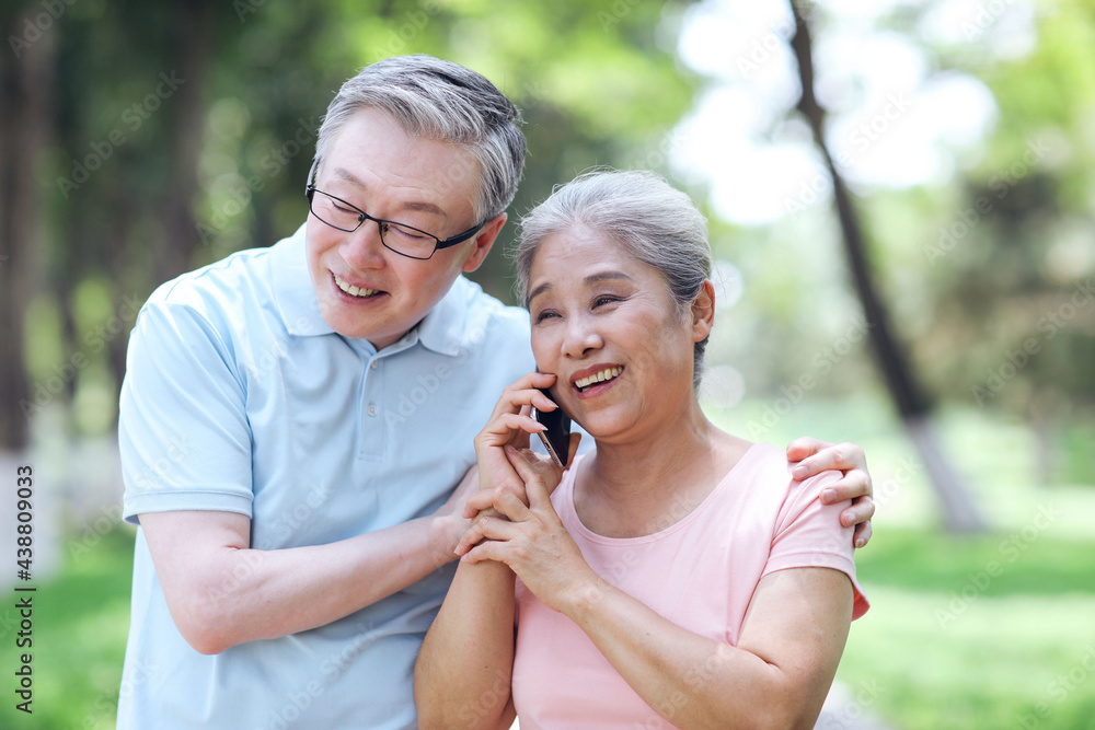 Happy old couples use mobile phones to make calls outdoors