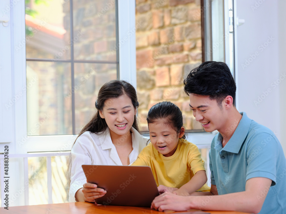 A Happy family of three using laptop