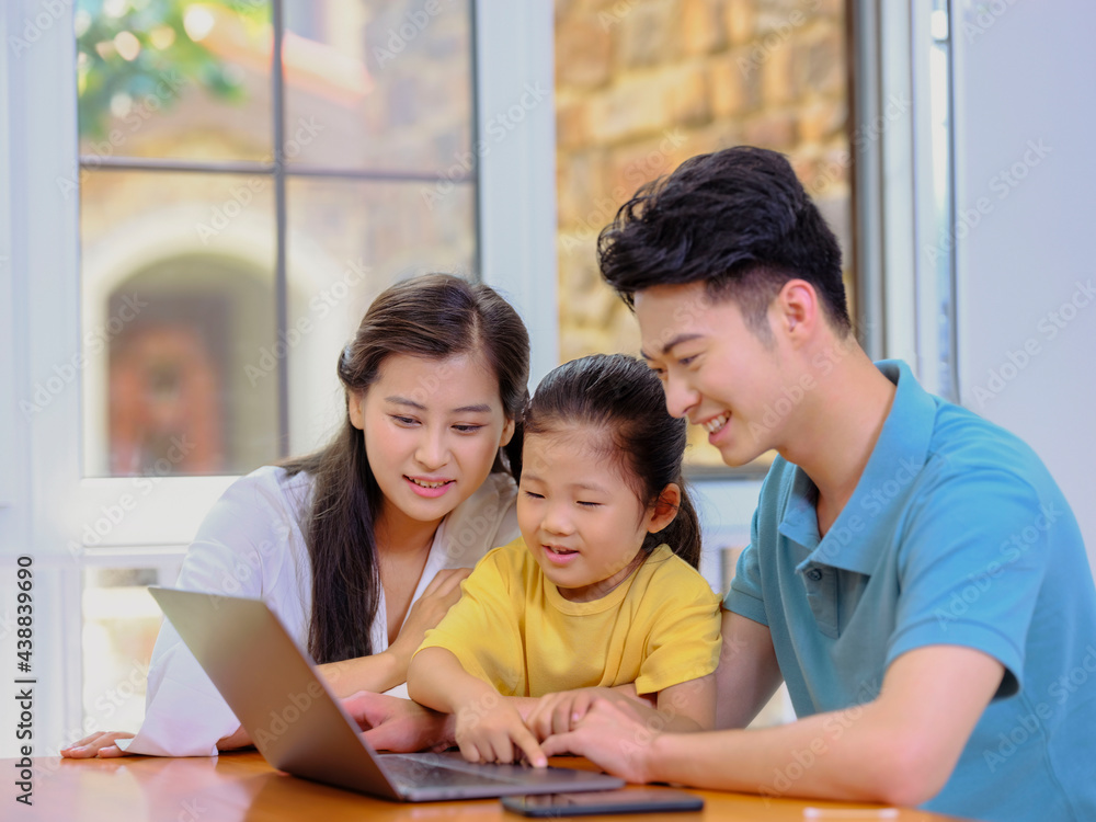 A Happy family of three using laptop