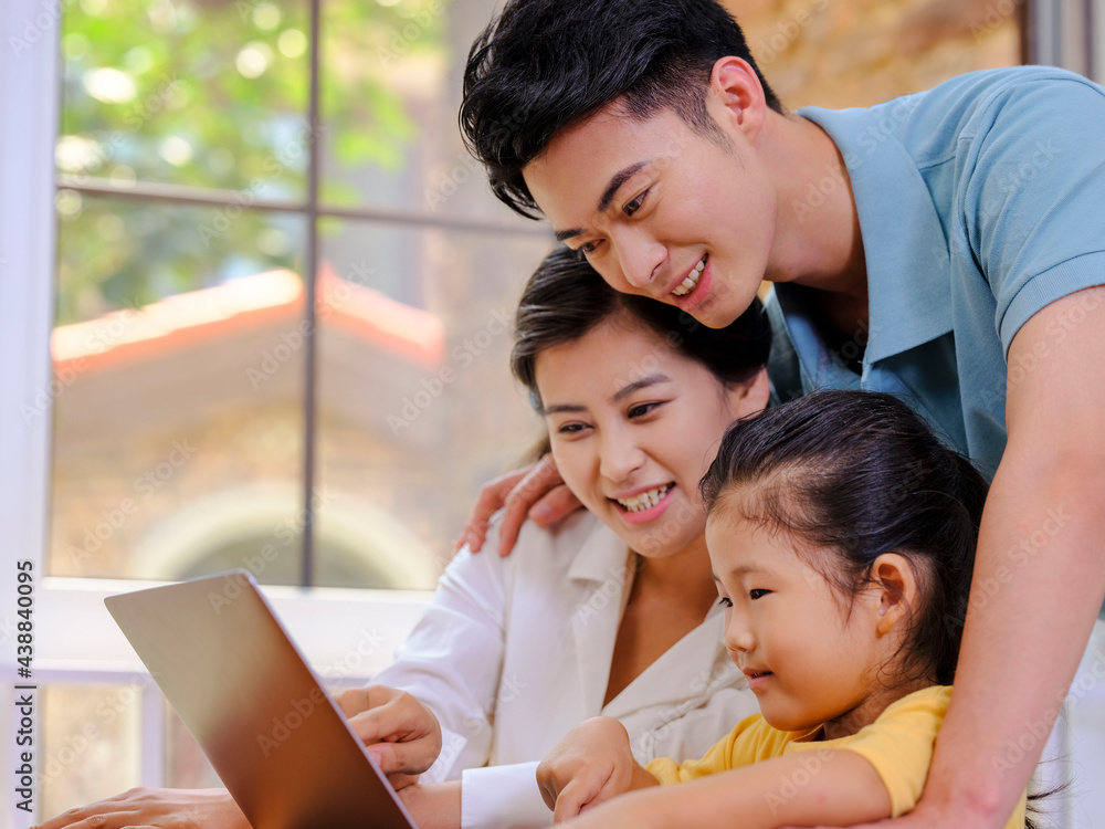 A Happy family of three using laptop