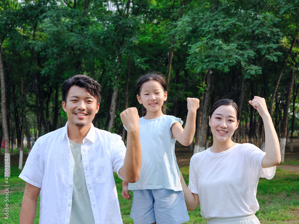 Happy family of three playing in the park