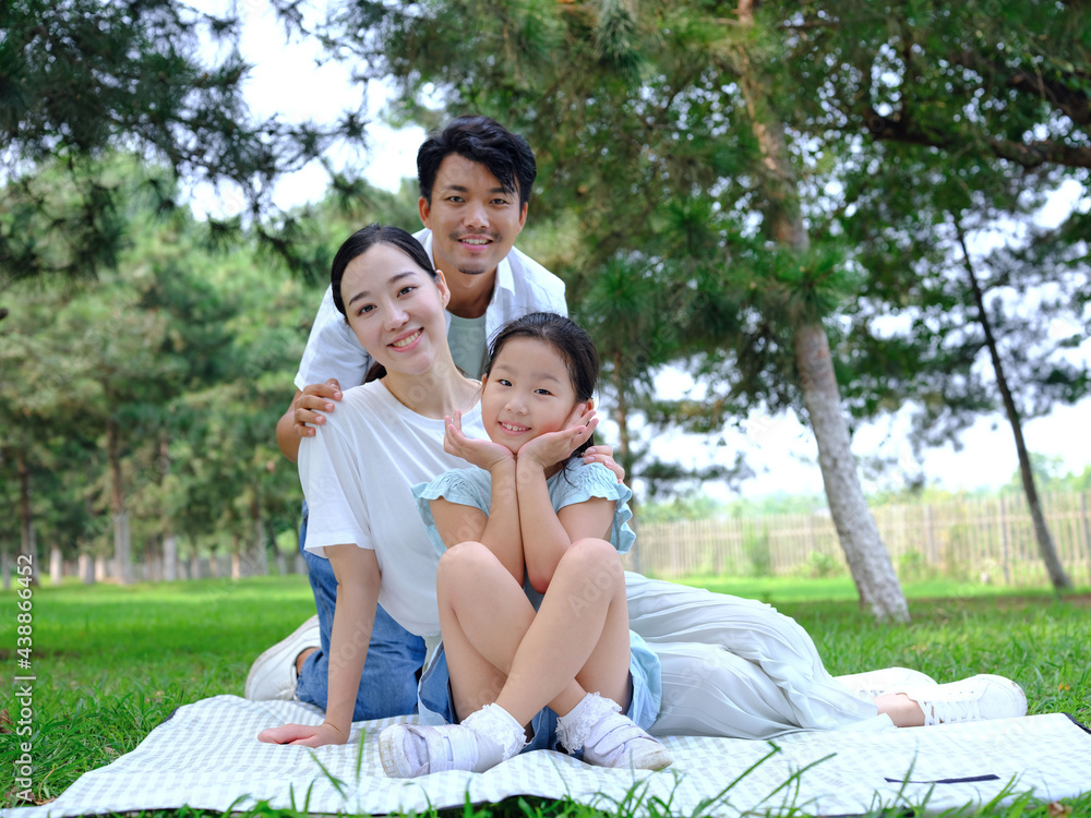 Happy family of three playing in the park